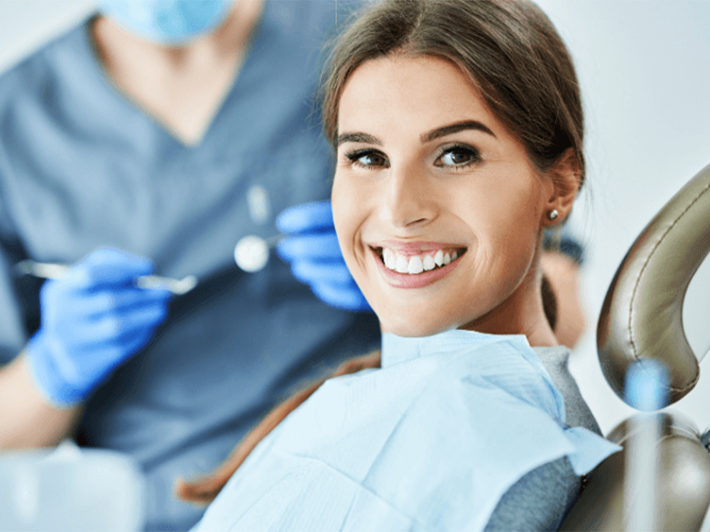 woman-smiling-with-the-dentist-in-the-background